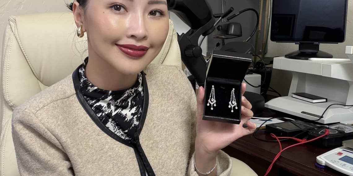 Trang Pham, Master Gemologist Appraiser at La Jolla Gem Appraisal, examining a collection of estate jewelry, diamond rings, and antique jewelry in San Diego